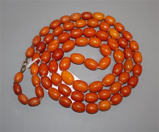 A single strand oval amber bead necklace, gross weight 104 grams, 123cm.